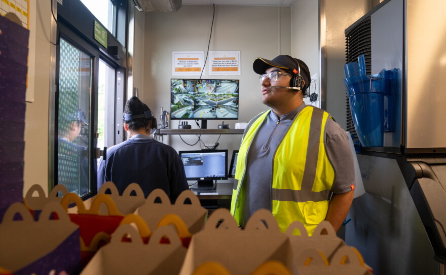 Ebert Velasquez Ramos (right) works at the drive-through at a McDonald's in Morningside, Md. He doesn't have a car so he sometimes turns to Escalate, a startup that provides Uber vouchers for workers who need last-minute rides among other support.
