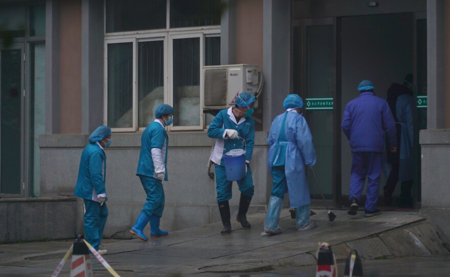 Hospital staff wash the emergency entrance of Wuhan Medical Treatment Center, where patients infected with a new virus are being treated, in Wuhan, China, on Wednesday.