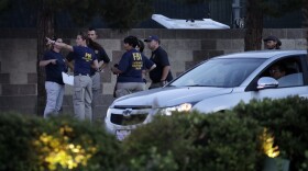 FBI agents confer outside of the concert grounds where a mass shooting occurred in Las Vegas, Tuesday, Oct. 3, 2017. 