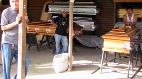 Three Guatemalan coffin builders, who make $7 a day, debate the risk of moving to the United States illegally. Marvin Gomez (far left)  was deported after spending five months in an American prison. Jose Rodas (middle) is considering the voyage north. Americo Barahona says it's not worth the risk.