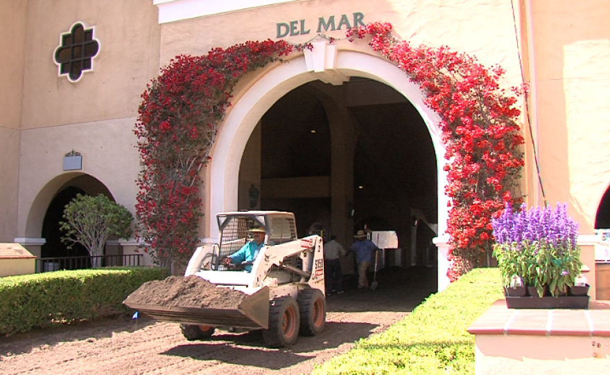 Workers lay down layers of dirt in the paddock at the Del Mar racetrack, July 11, 2017.