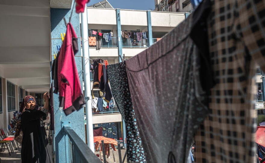 A Palestinian woman hangs up washing Wednesday in a school run by the U.N. Relief and Works Agency, where some families are now living, following Israeli raids on Beit Hanoun in northern Gaza.