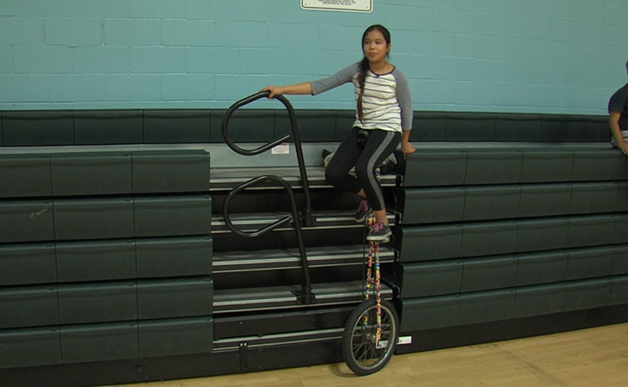 Ten-year-old Cinthia Cruz balances on a the five-foot-tall unicycle nicknamed "the giraffe" at the Fern Street Circus after-school program at the Mid-City Gym in City Heights, Jan. 30, 2018.