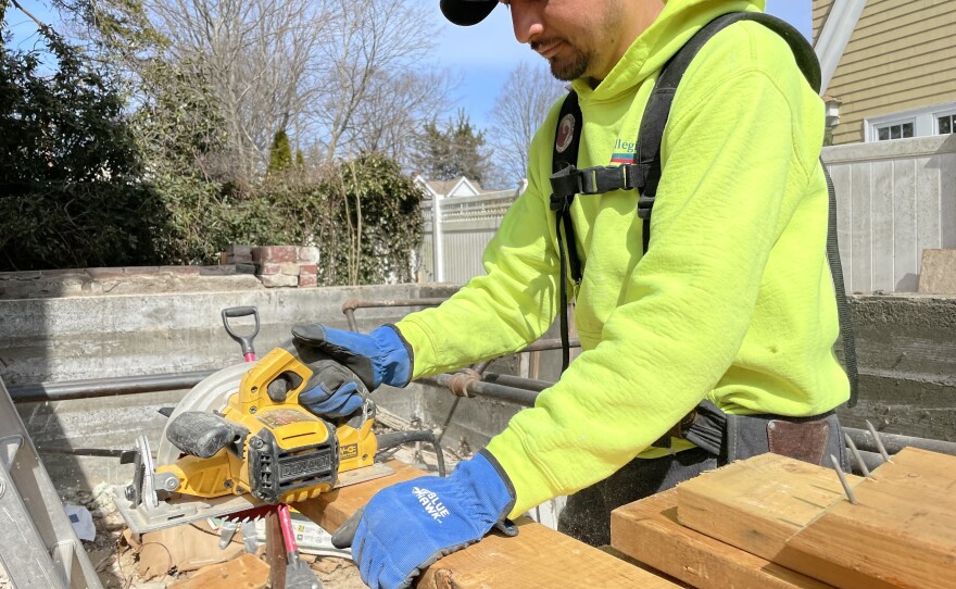 Hipolito Herrador is fashioning supports to hold up a portion of an existing house so an additional apartment unit can be built onto it. Some states and towns are changing their zoning rules to make it easier to add such "accessory dwelling units."