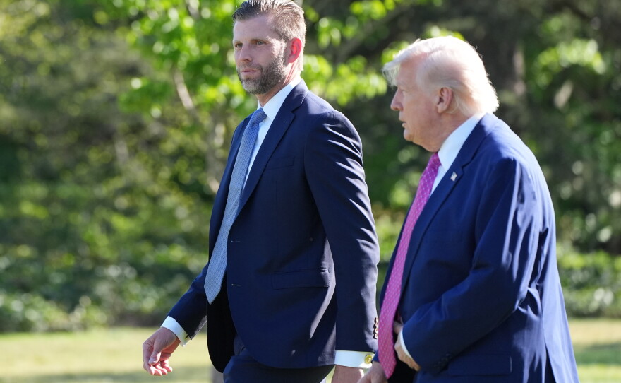 President Donald Trump walks with Eric Trump as they prepare to depart on Marine One from the South Lawn of the White House, Friday, April 10, 2026, in Washington.