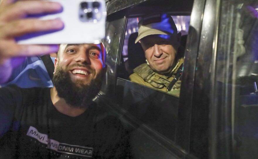 Yevgeny Prigozhin, the owner of the Wagner Group military company, right, sits inside a military vehicle posing for a selfie photo with a local civilian on a street in Rostov-on-Don, Russia, on Saturday.