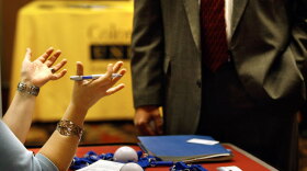 An employer speaks to a potential hire at a career fair in Denver.