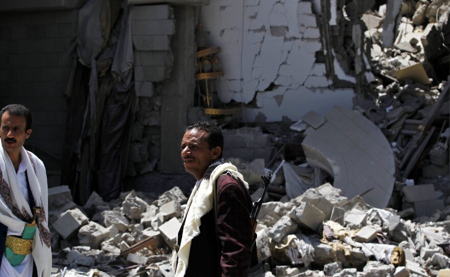 Gunmen loyal to former Yemeni President Ali Abdullah Saleh, stand amid the ruin of Saleh's residence following an airstrike carried out by the Saudi-led alliance in the capital, Sana, on Sunday.