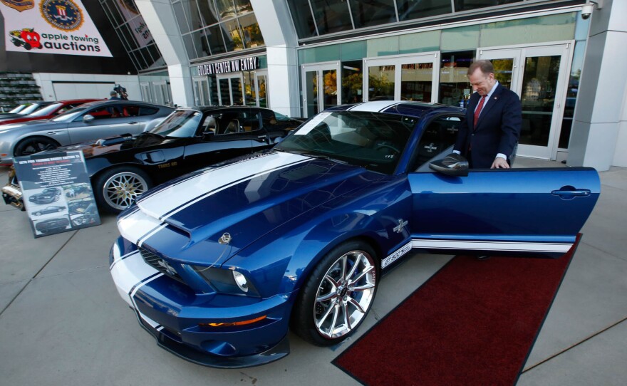 McGregor Scott, who was the the U.S. Attorney for the Eastern District of California in 2019, looks over a cars seized from Jeff and Paulette Carpoff in Sacramento, Calif. The Carpoffs owned a San Francisco Bay Area solar energy company and pleaded guilty for participating in what federal prosecutors called a massive Ponzi scheme that defrauded investors of $1 billion.