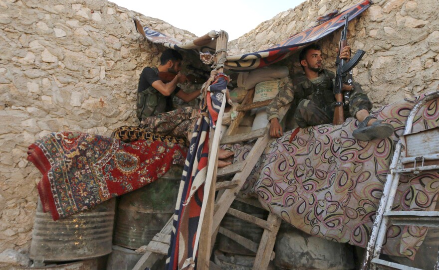Rebel fighters sit in a shelter in Aleppo on July 8. The rebels are in the eastern part of the city but are facing increasing pressure from the government army.