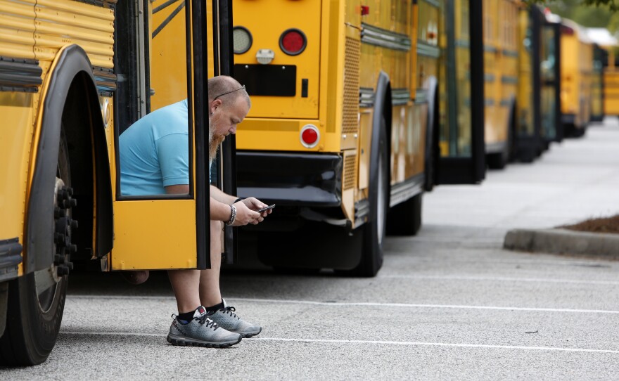 Jay McAbee, a bus driver with the Greenville, S.C., school district, waits by his bus in Charleston, S.C., in October of 2016, for word of when to start evacuating the city's residents in advance of Hurricane Matthew. Simply having enough buses to carry pets as well as people can be key to convincing residents they need to leave ahead of a big storm, emergency responders say.