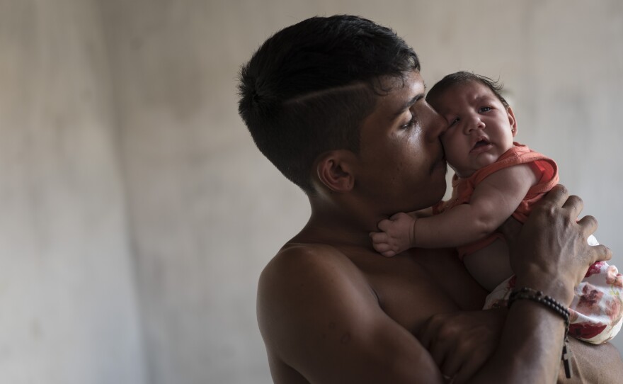 Dejailson Arruda holds his daughter, Luiza, at their house in Santa Cruz do Capibaribe, Pernambuco state, Brazil, in this December 2015 photo. The child was born with microcephaly.