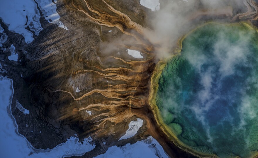 The colors of Yellowstone's Grand Prismatic Spring come from microbes called thermophiles, which thrive in scalding water. The green is chlorophyll the thermophiles use to absorb sunlight.