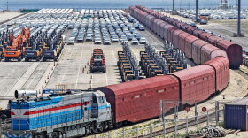 Heavy equipment and cars are prepared for shipment by rail in Yantai, eastern China's Shandong province, on June 20, 2026.