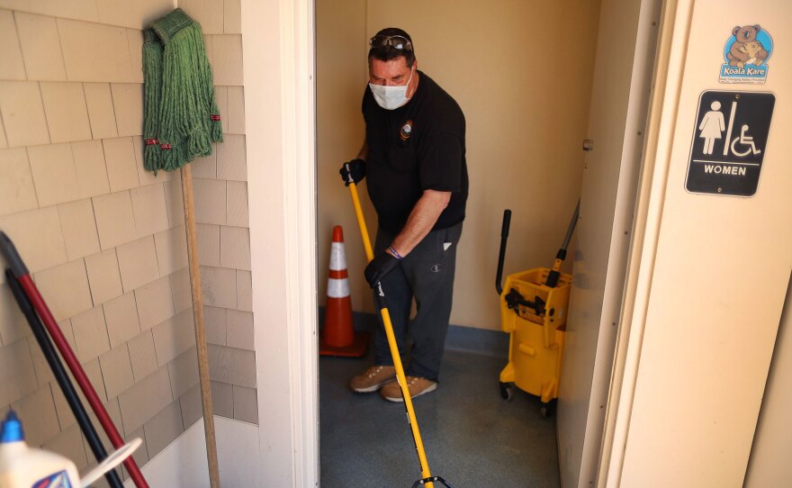 Town worker Steve Crowley washes and disinfects the public restroom at Mayflower Beach, in Dennis, Mass., last week. As stay-at-home restrictions are lifting, many people are concerned about using public restrooms.