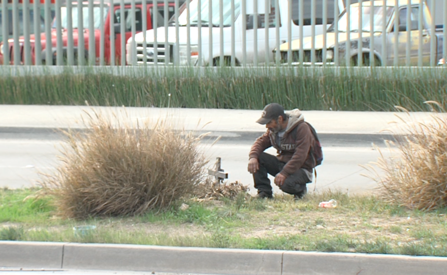 Jose Alberto Zavala, known as Chapo, kneels before the cross he erected in memory of a friend killed in a car accident, Jan. 15, 2016.
