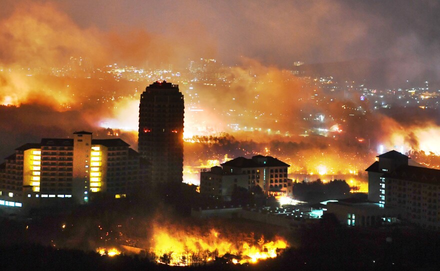 A forest fire is seen raging near buildings in Sokcho, South Korea. South Korea mobilized troops and helicopters to deal with the massive blaze that roared through forests and cities along the eastern coast.