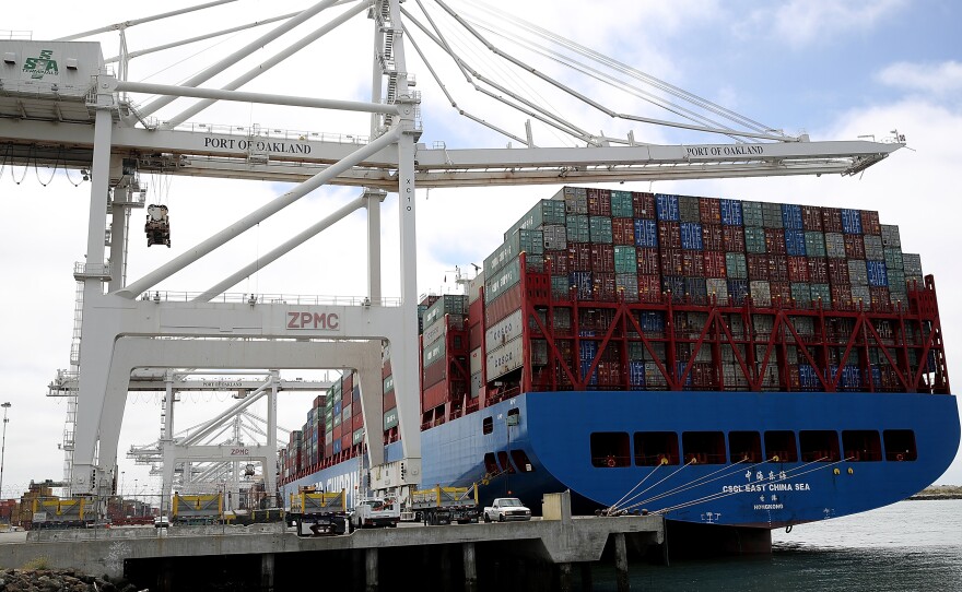 A container ship sits in a berth at the Port of Oakland in California last year. President Trump announced additional tariffs on imports from China on Thursday.