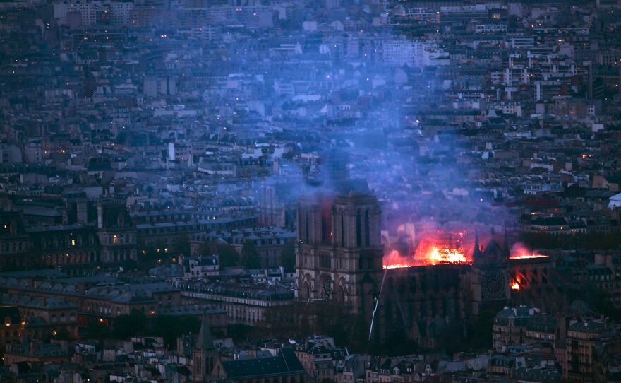 From Montparnasse Tower, flames and smoke can be seen billowing from the roof at Notre Dame Cathedral, about 2 miles away.