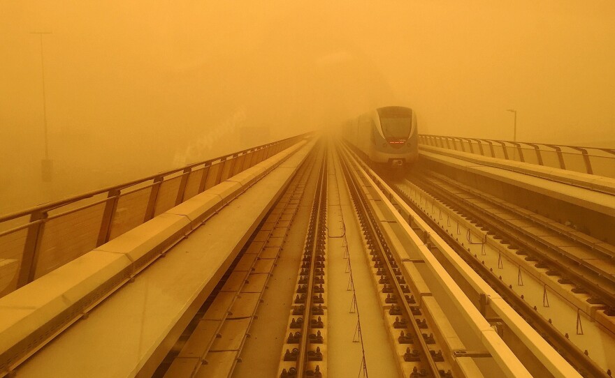 A Dubai metro train is seen driving through a sandstorm that engulfed the city Thursday, setting off travel delays.