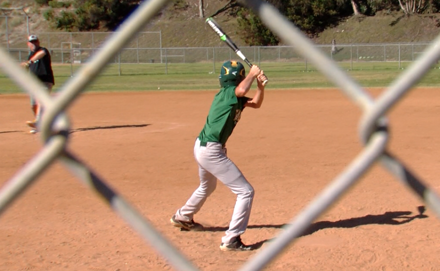 A San Carlos All Star coach pitches to a team member at practice on July 5, 2016