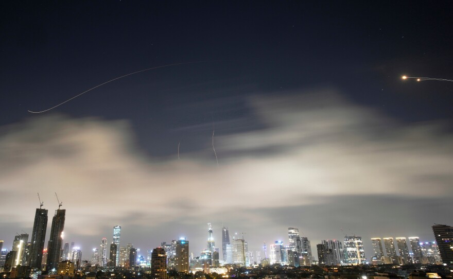 Israeli air defense system fires to intercept missiles during an Iranian attack over Tel Aviv, Israel, early Sunday, March 15, 2026.