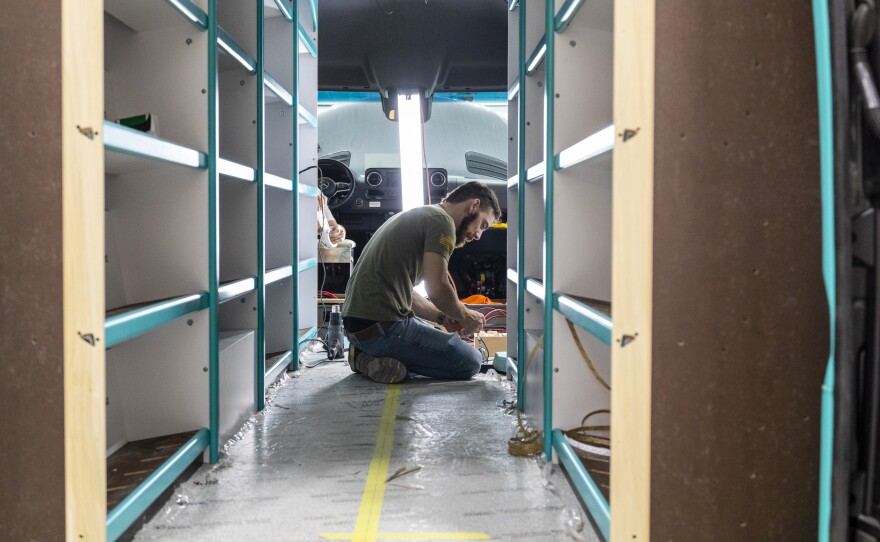 An Advanced RV employee works on a custom RV that will eventually become a mobile library.
