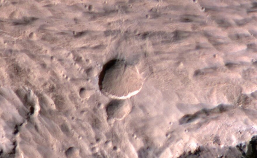A photograph of the new crater (large, center). Take by the Mars Reconnaissance Orbiter's High Resolution Imaging Science Experiment.