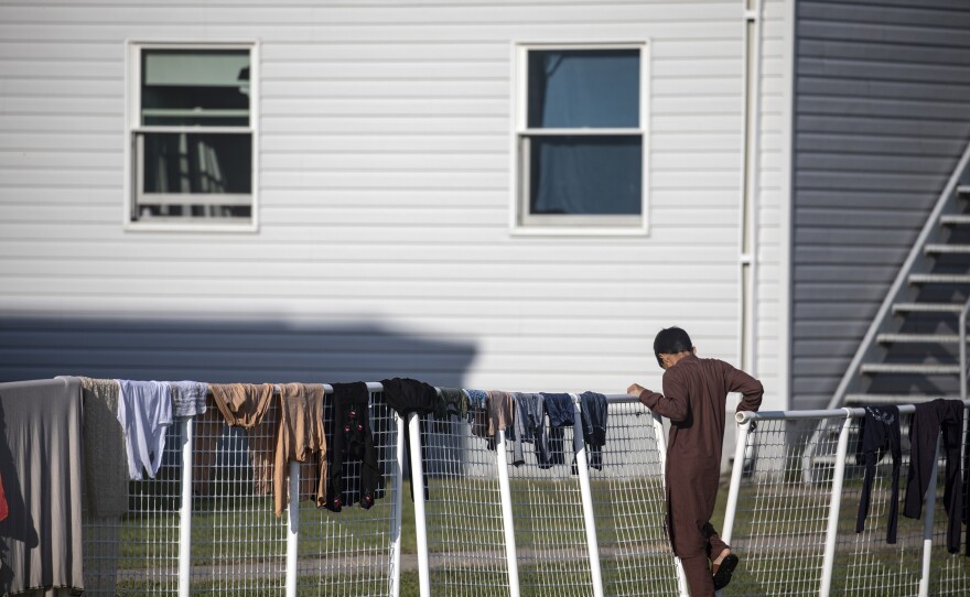 An Afghan refugee stands outside temporary housing at Fort McCoy.