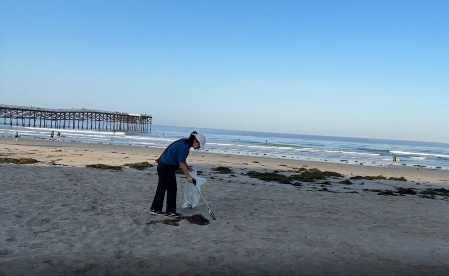Vi Nguyen picks up trash on Pacific Beach in this undated photo. Nguyen is a local pediatrician who has been picking up plastic along San Diego's coastline for the past seven years.