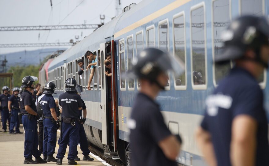 Police check the documents of migrants aboard a train at the Bicske Railway Station, in Bicske, Hungary, on Thursday.