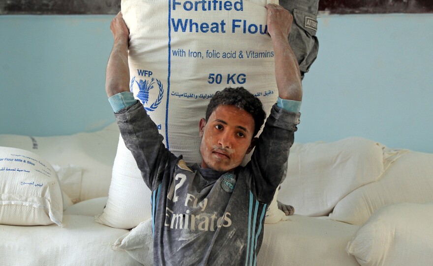 Yemenis receive humanitarian aid provided by the World Food Programme in the capital Sanaa. WFP hopes to raise about $18 billion to assist some 140 million people worldwide this year. To date member states have provided about half of that.