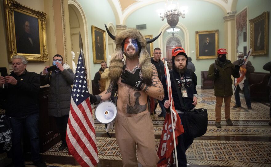 Jacob Chansley, the self-styled "QAnon shaman" and Navy veteran, confronts U.S. Capitol Police officers during the January 6 insurrection.