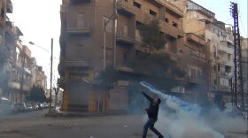 The Syrian uprising began a year ago. Here, a protester in Homs throws a tear gas canister back at security forces on Dec. 27, 2011. 