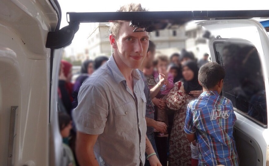 Abdul-Rahman Kassig, who was formerly known as Peter, is shown with a truck filled with aid supplies for Syrian refugees. The American aid worker was seized by the Islamic State in October 2013 and the group is now threatening to kill him.