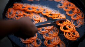 A street vendor fries <em>jalebi,</em> a treat made of batter and crystallized sugar that is popular in Pakistan, Afghanistan and India.