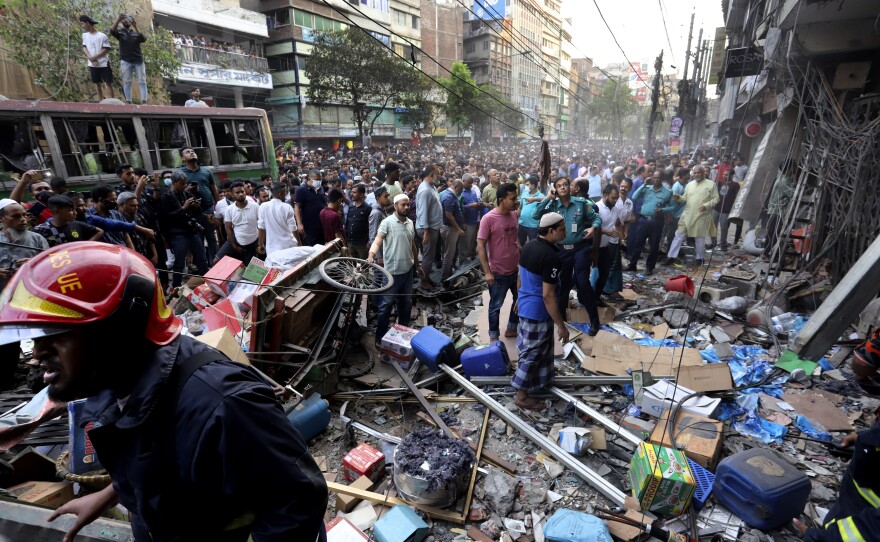 Onlookers gather outside the site of the explosion at a commercial building in Dhaka, Bangladesh, Tuesday.