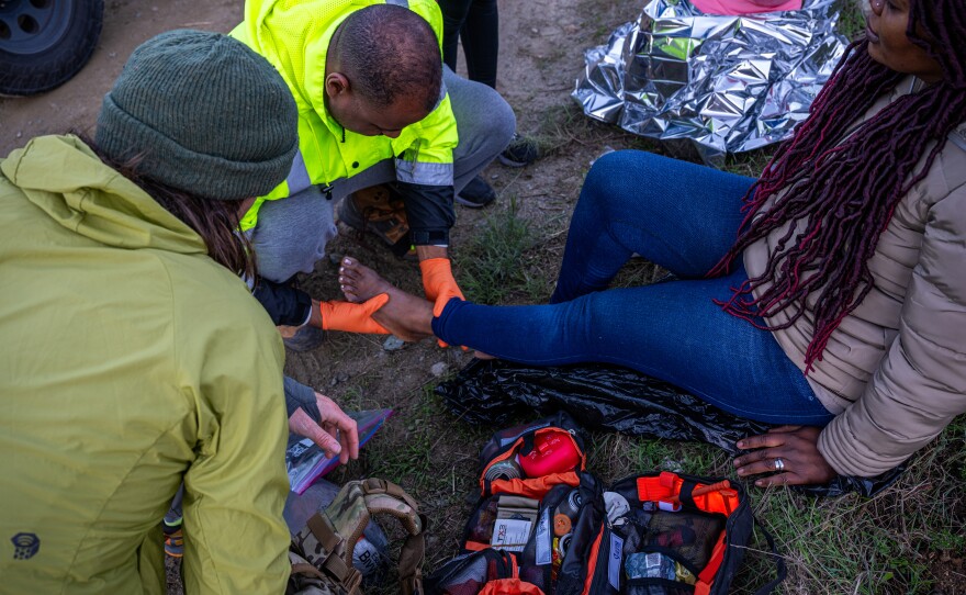 Members of the Borderlands Relief Collective attend to the wounds of a woman from Guinea with lacerations and blisters on her feet.