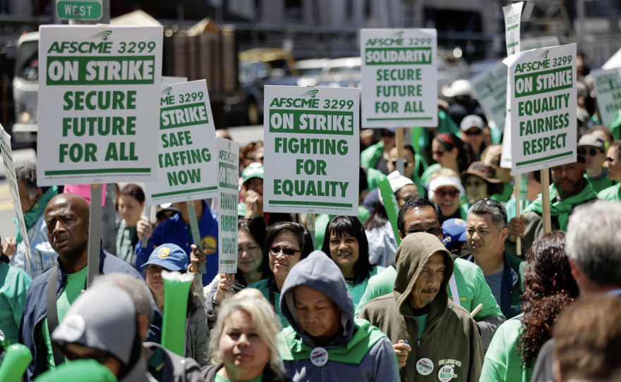 El gobernador Gavin Newsom quiere posponer un aumento del salario mínimo para los trabajadores de la salud de California que entrará en vigor en junio. Algunos empleadores ya han comenzado a aumentar los salarios. Aquí, trabajadores en huelga marchan afuera del campus Parnassus de la Universidad de California en San Francisco el 7 de mayo de 2018. Foto de Marcio José Sánchez, AP Photo