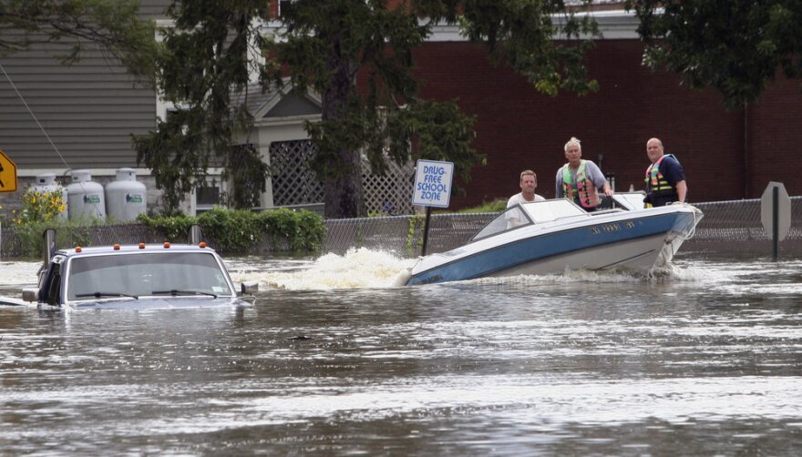 A motorboat passes a submerged pickup truck on Main Street in Washingtonville, N.Y., on Sunday following heavy rains from Tropical Storm Irene.