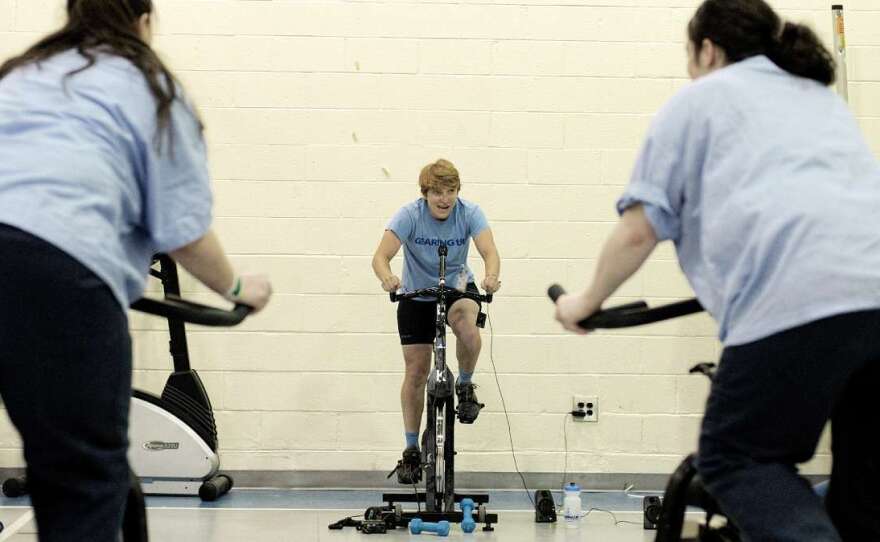 Instructor Erica Tibbetts uses a portable audio system to provide a soundtrack for the spinning class.