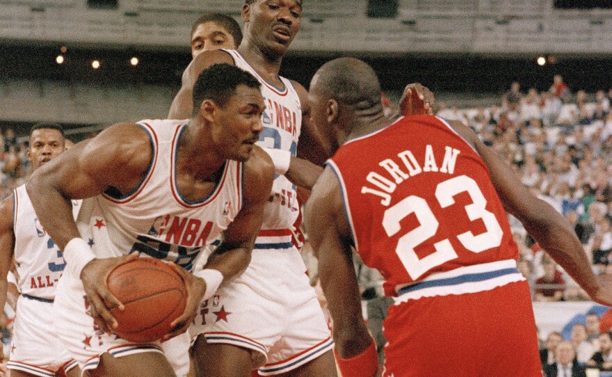 The West's Karl Malone (left) goes eyeball to eyeball with the East's Michael Jordan while Akeem Olajuwon looks down on the scene in the second half of the NBA All-Star game on Feb. 2, 1989.