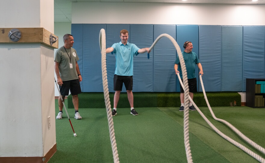 One of Cody's many hobbies is exercising at the gym. Health and wellness coordinator Brian Prendergast (left) instructs Cody and another Next Steps client.