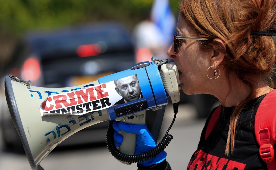 An anti-Netanyahu protester shouts slogans during a demonstration in front of the Knesset in Jerusalem on Wednesday.