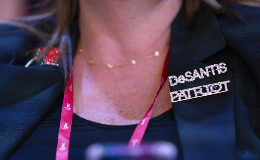 A woman attending the Conservative Political Action Conference, CPAC 2023, wears a DeSantis pin at the National Harbor, in Oxon Hill, Md., Thursday, March 2, 2023.