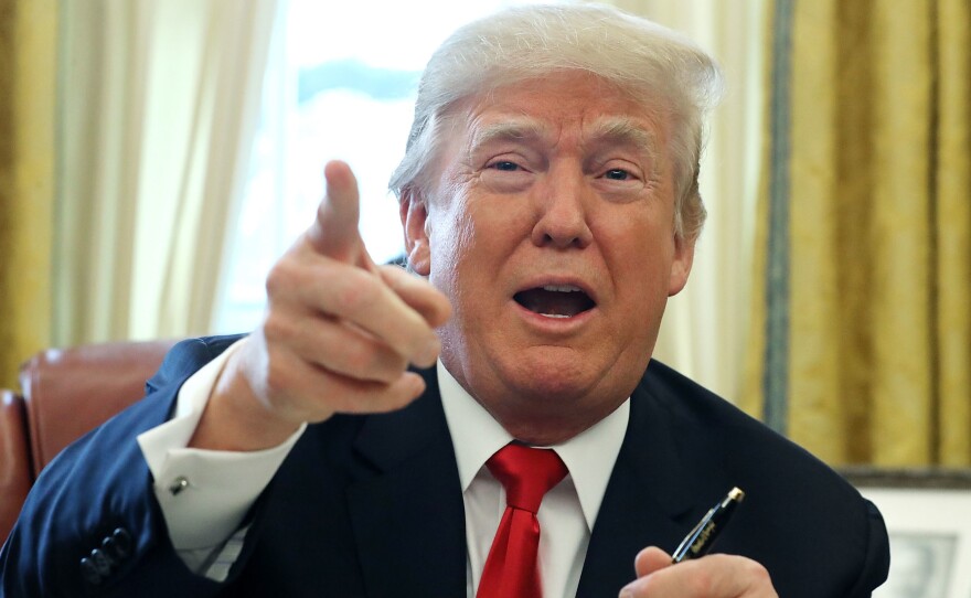 President Trump talks with journalists at the White House after signing the tax overhaul into law on Friday.