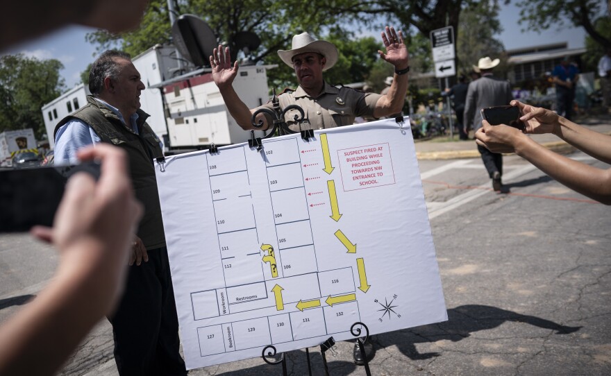 Members of the media take photos of a map of the school which was used at a press conference held outside Robb Elementary School on Friday, May 27, 2022, in Uvalde, Texas.