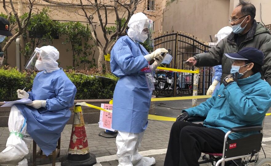Workers in protective gear register residents for COVID-19 testing in the Jingan district of western Shanghai, China, on April 1, 2022. Shanghai allowed 4 million more people out of their homes Wednesday as coronavirus rules that shut down China's largest city eased and some factories resumed operation.