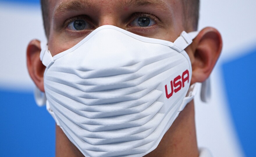 Caeleb Dressel wears a USA-branded face covering while waiting to receive his gold medal after the final of the men's 4x100 meter freestyle relay swimming event during the Tokyo Olympics on Monday.