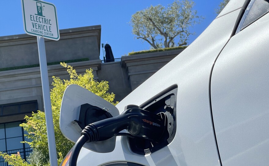An electric car charges at a mall parking lot in Corte Madera, Calif., on June 27. The lack of charging infrastructure is seen as one of the key roadblocks to adopting electric cars.